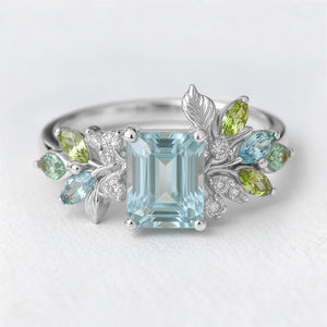 Calista’s Bloom | Emerald Cut Aquamarine Engagement Ring with Asymmetric Floral Accents.