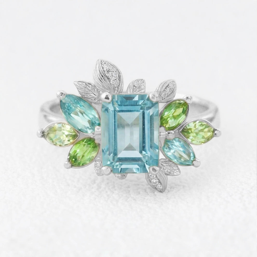 Flora’s Spring | Emerald Cut Blue Aquamarine Leaf Halo Engagement Ring.